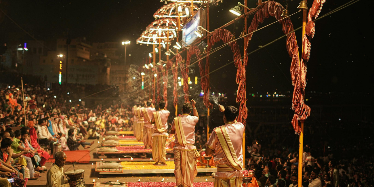 Several people dressed in traditional clothing gather on a platform, representing their cultural identity and community spirit.
